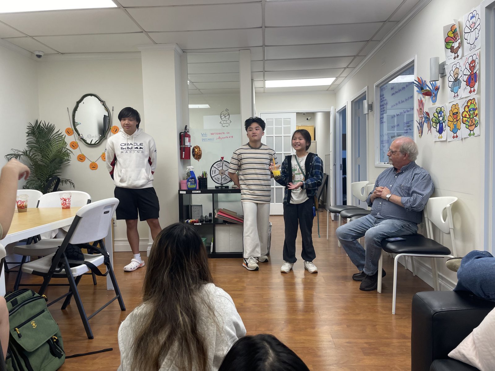 A mentor watching students present at the AASuccess office